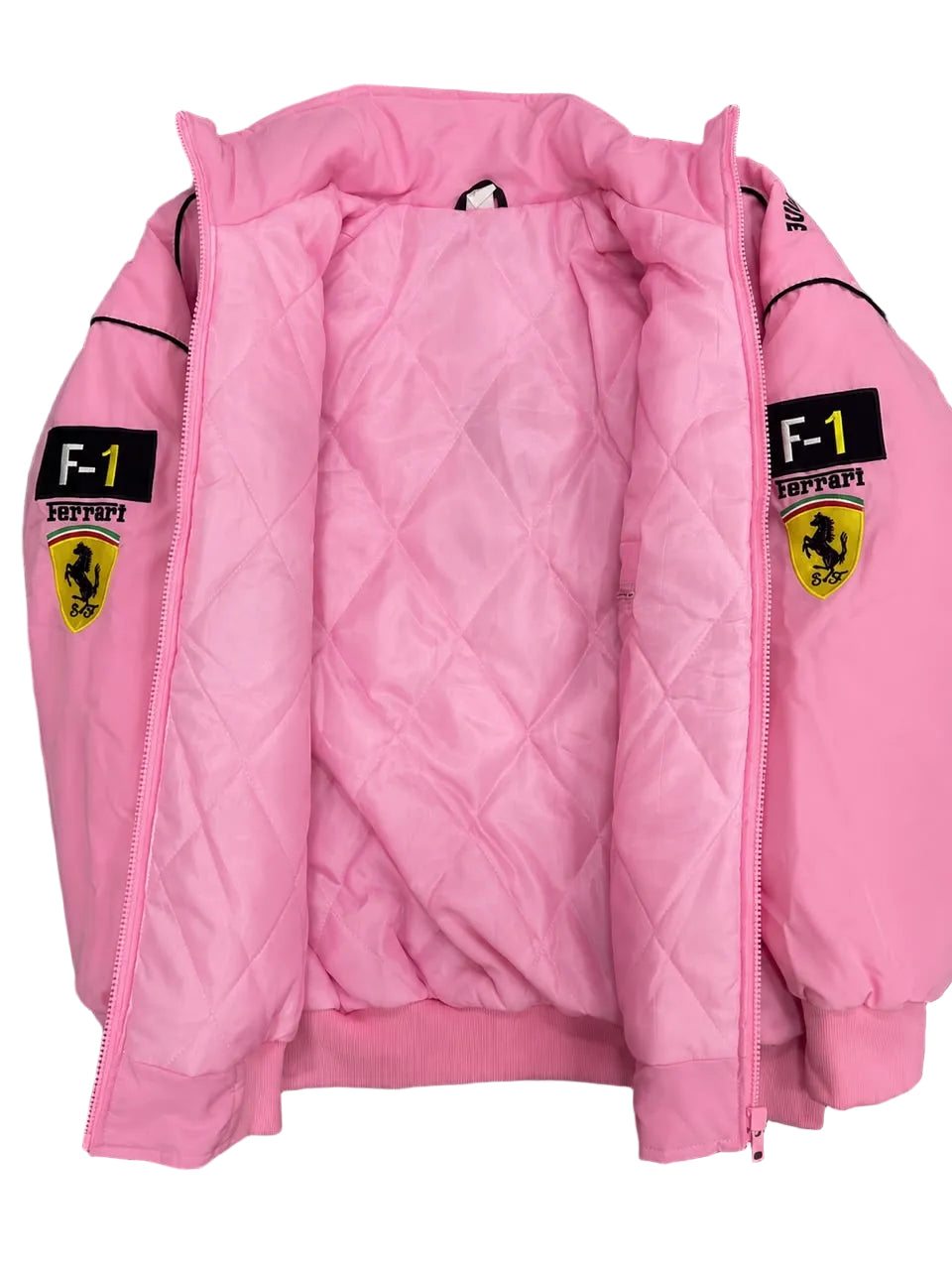 A pink quilted jacket with Ferrari F-1 branding and patches on the sleeves, laid flat on a dark marble surface.