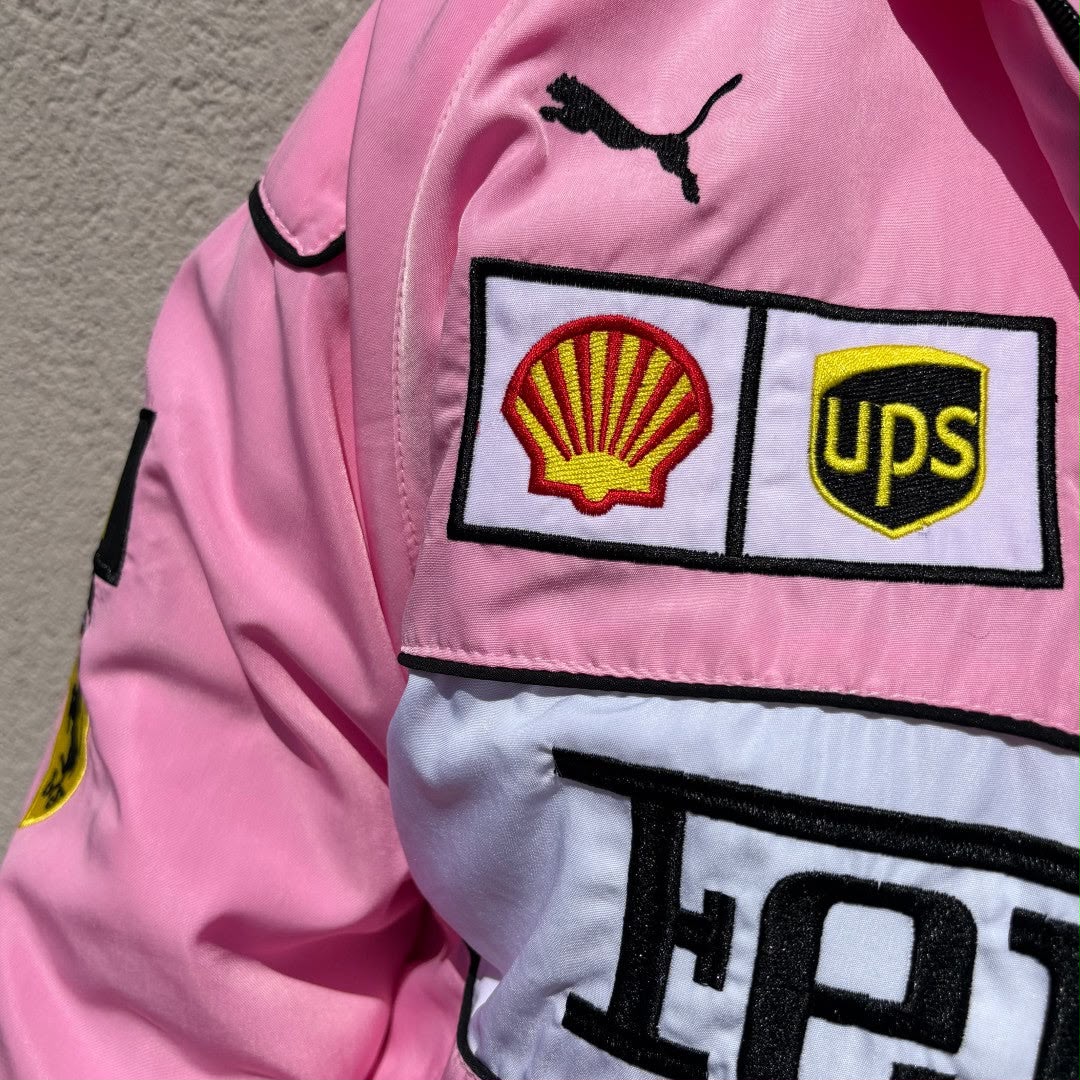 Pink jacket with Shell, UPS, and Ferrari logos on a plain background